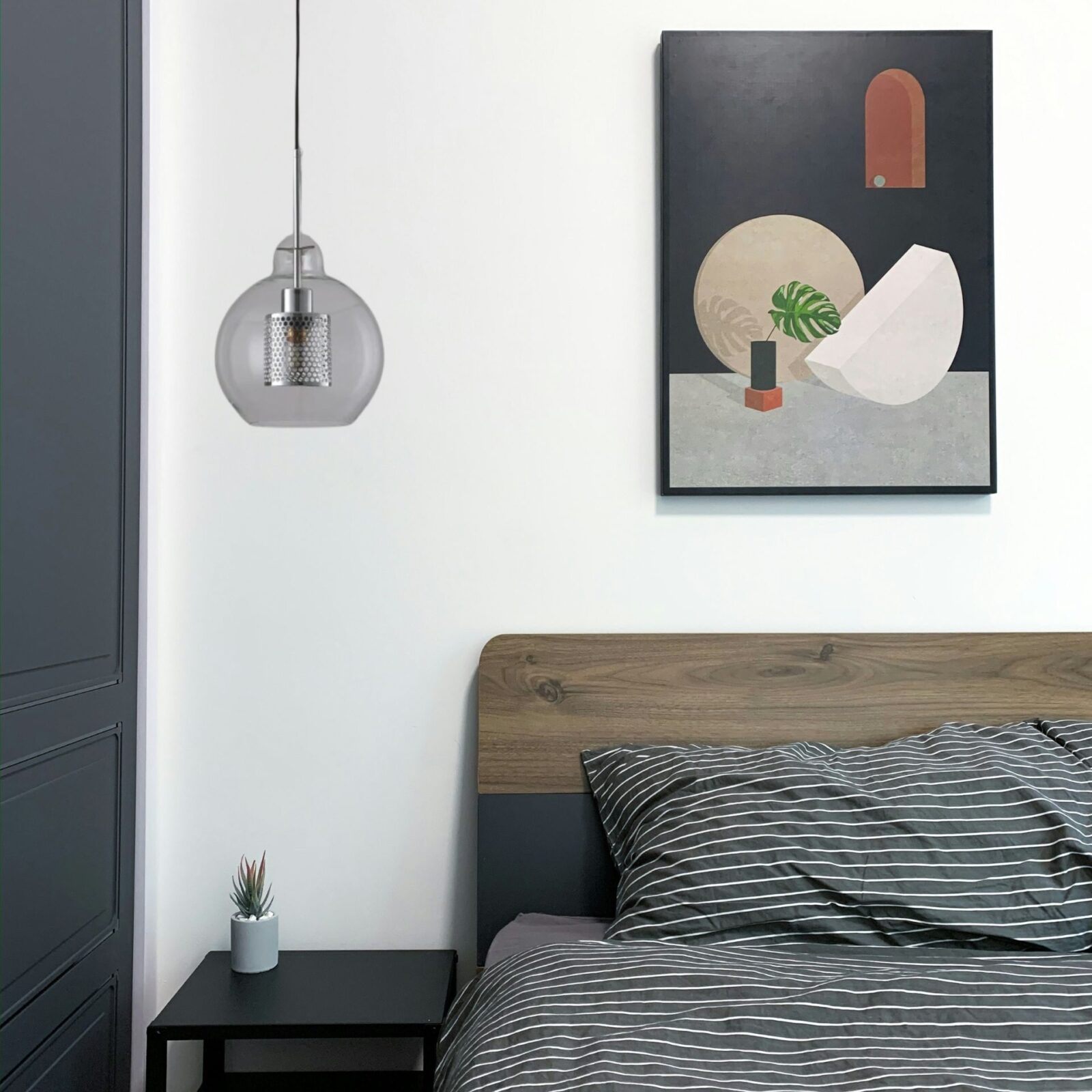 Suspension boule verre et meÌtal dans chambre adulte