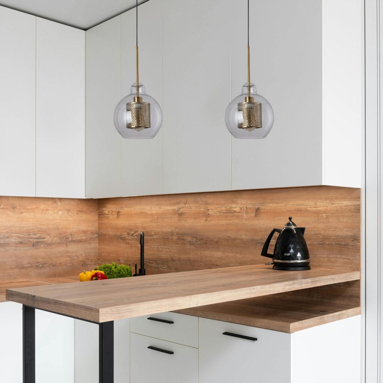Suspension boule verre et meÌtal dans cuisine blanche et bois