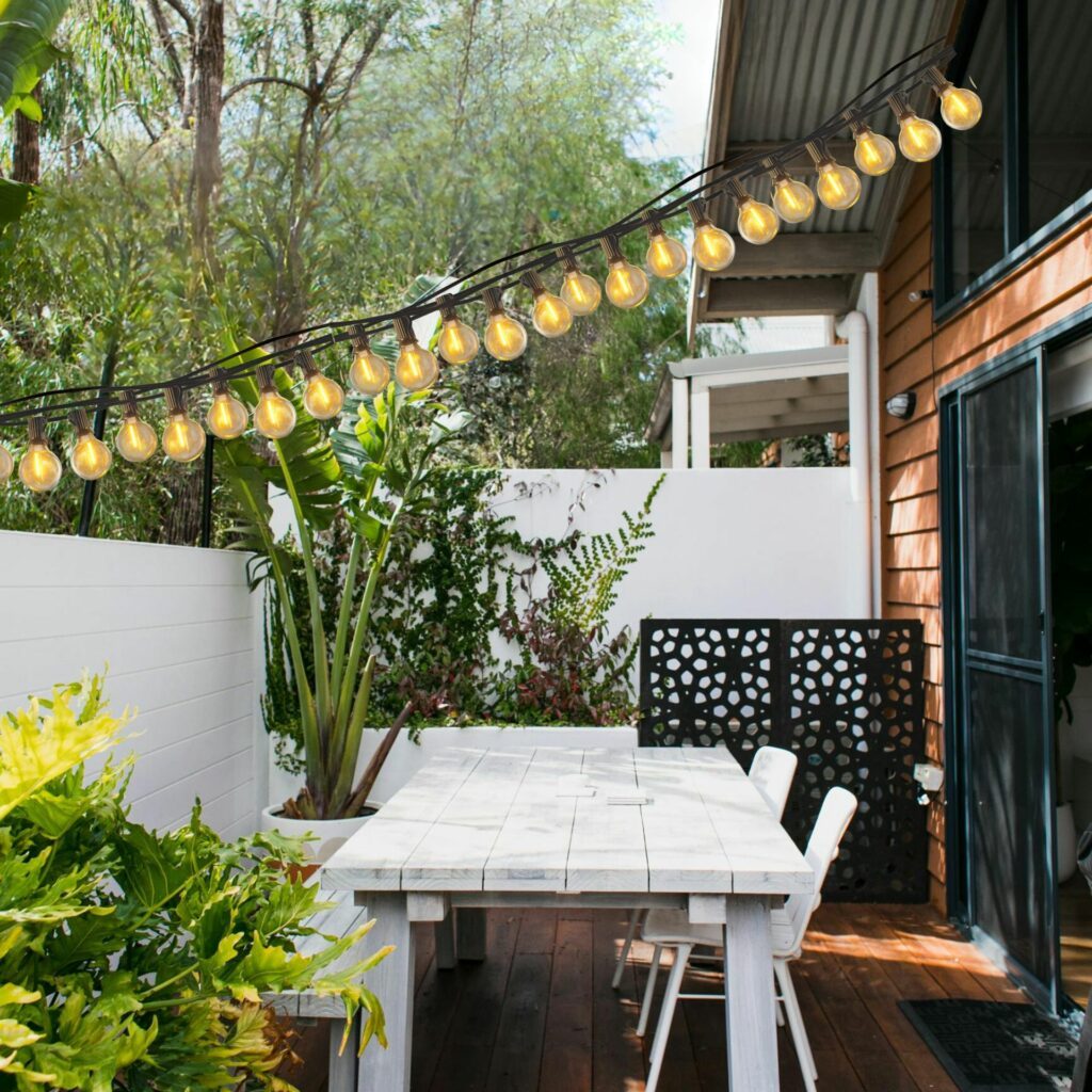 Suspension extérieure ampoule dans terrasse avec table et chaise blanche