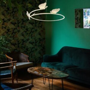 Suspension papillon design dans salon avec canapé vert