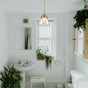 suspension laiton doré dans salle de bain blanche